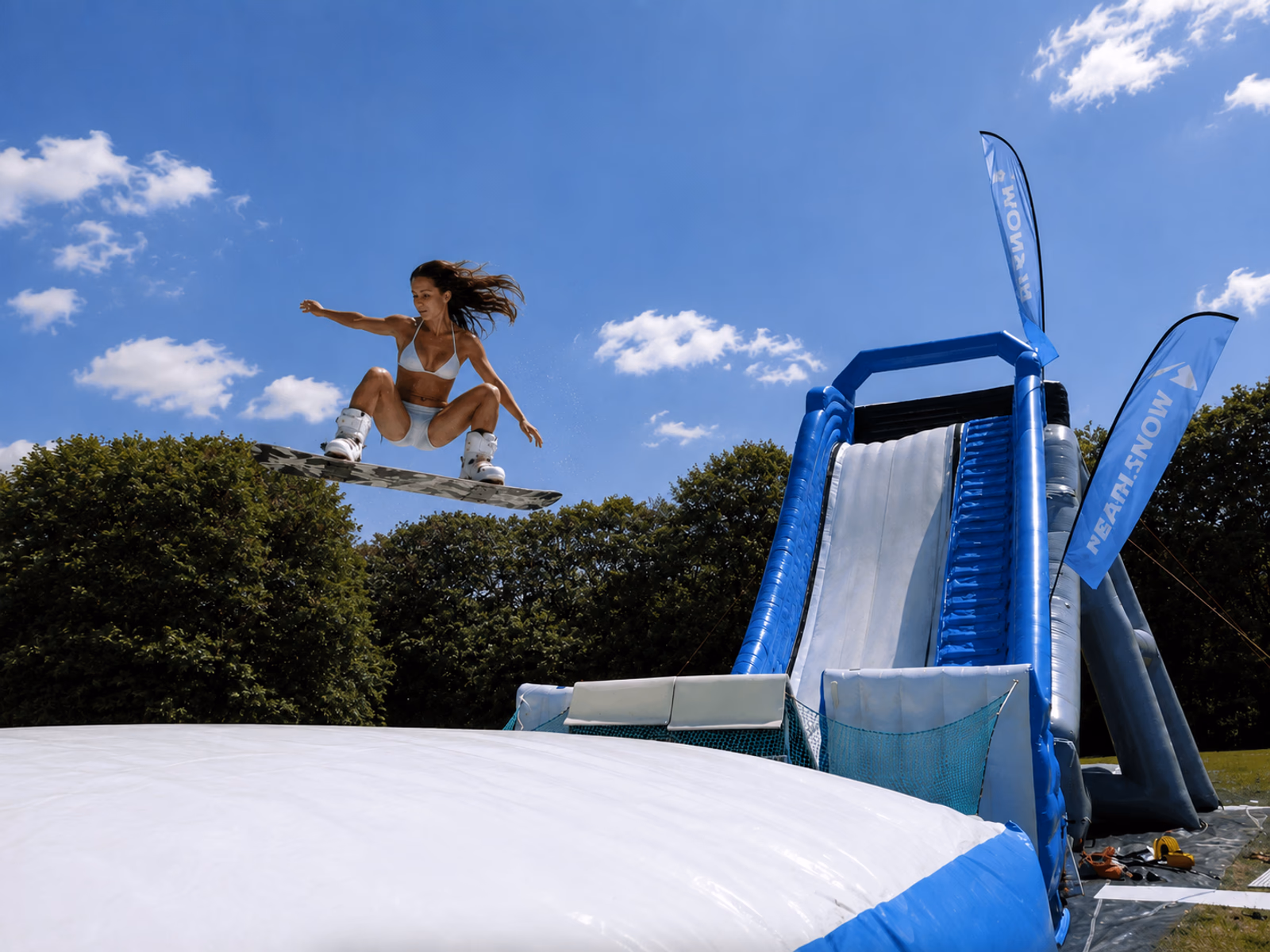 Snowboarder jumping on a Pearljump inflatable ramp
