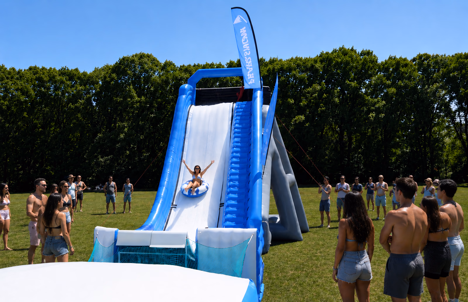 Friends tubing down a Pearljump slide on grass
